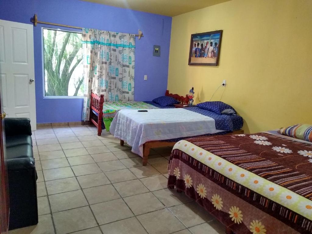 a bedroom with two beds and a window at Casa de Campo Tamasopo in Tamasopo