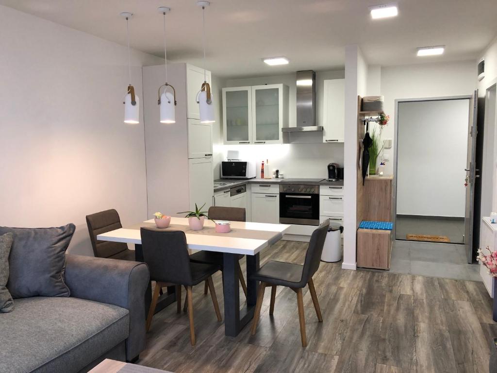 cocina y sala de estar con mesa y sofá en Juhar Apartman en Kőszeg