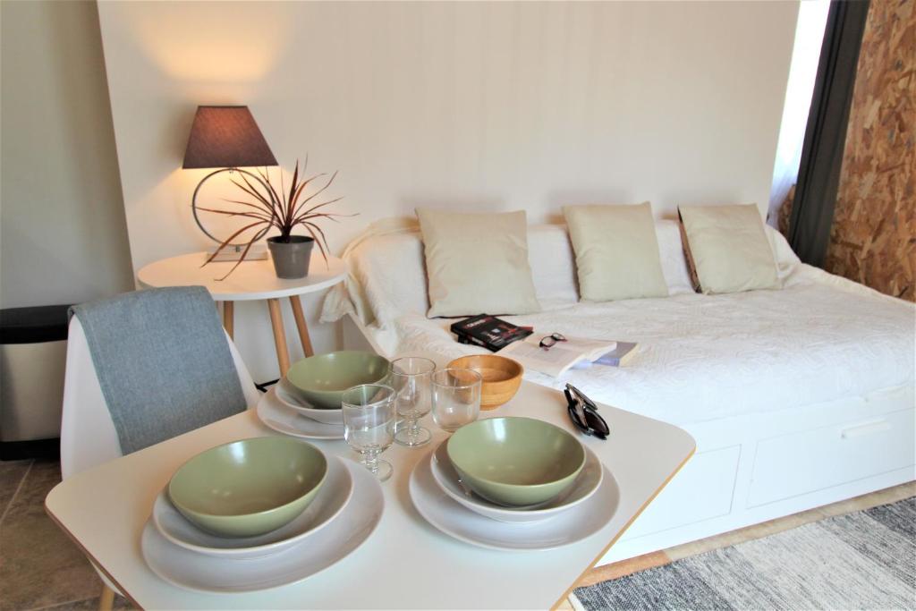 a living room with a table with plates and glasses at Les Bastidons de l'Isle - Le Saumane - 3 étoiles in LʼIsle-sur-la-Sorgue