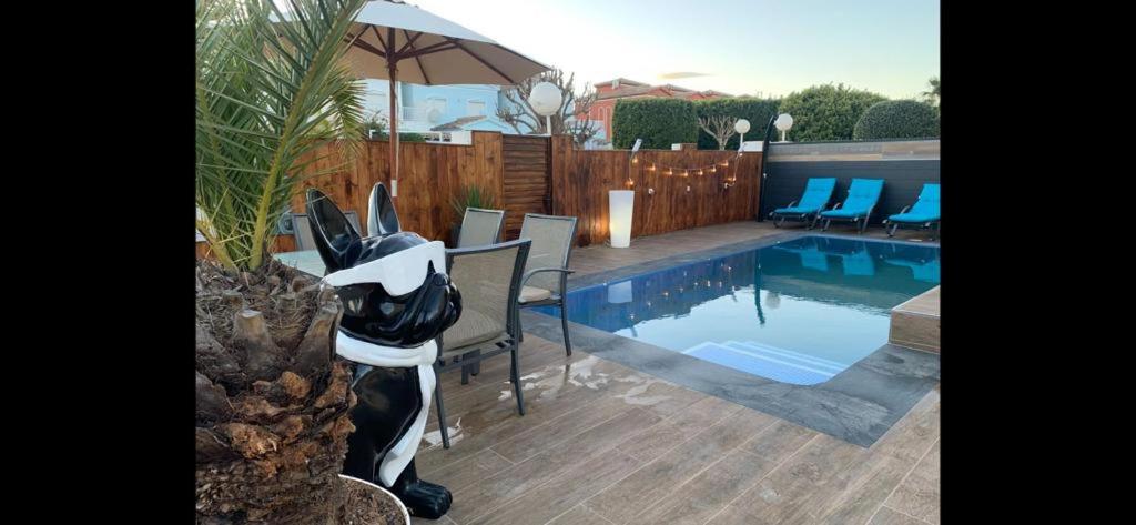 a backyard with a swimming pool with chairs and an umbrella at Jazmines 22 in Calpe
