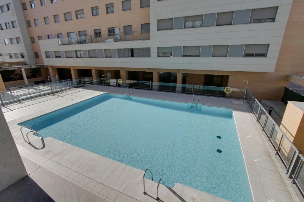 a large swimming pool in front of a building at Apartamento en primera línea de playa en Málaga in Málaga