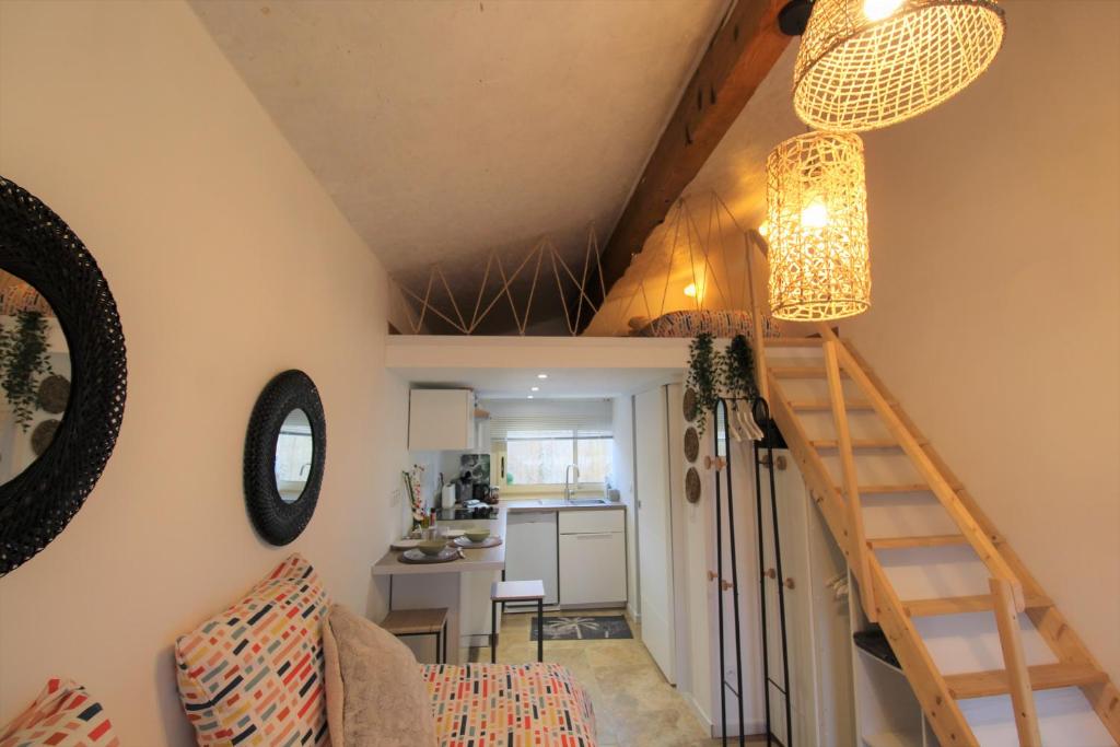 a living room with a staircase and a kitchen at Les Bastidons de L'Isle - st ju- 3 étoiles in LʼIsle-sur-la-Sorgue