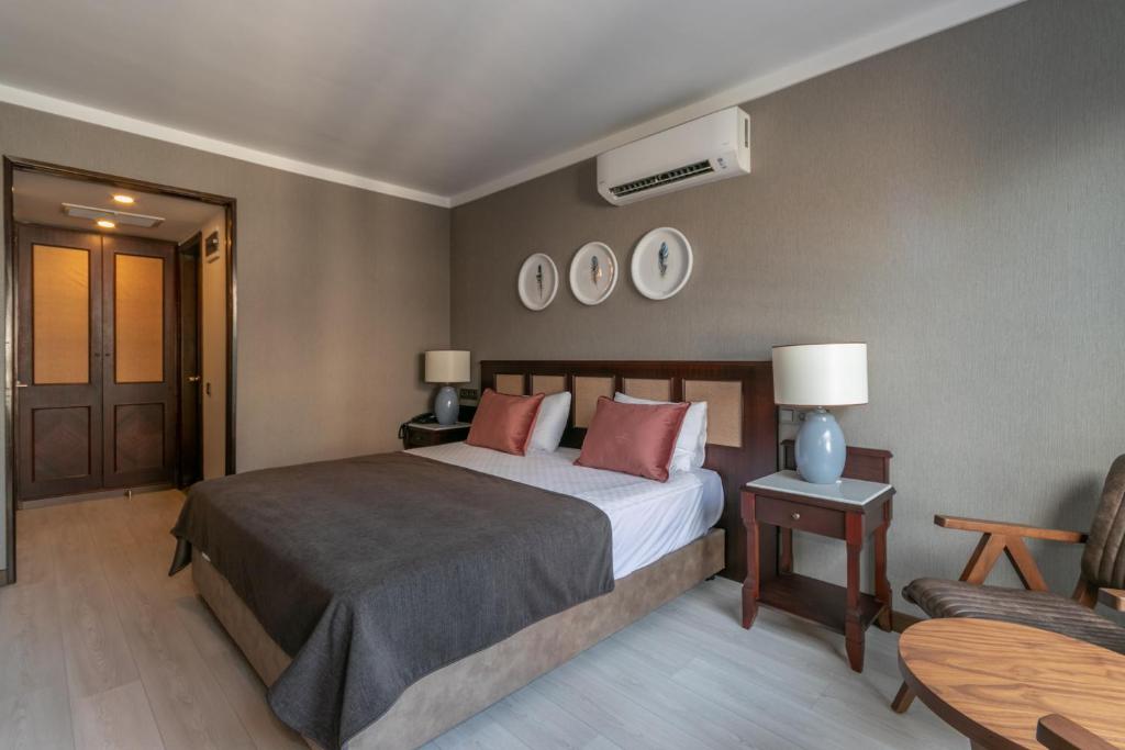 a bedroom with a bed and a table and a chair at Lara Park Hotel in Antalya