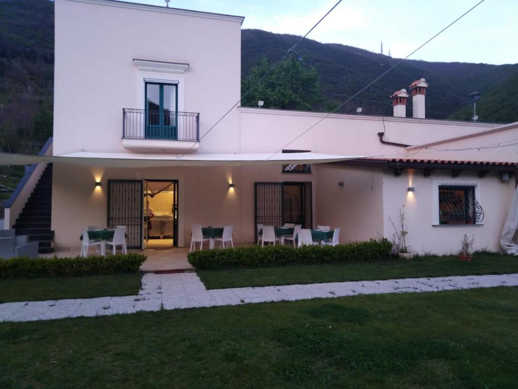 a white house with chairs and a patio at AGRITURISMO ANTICHI SAPORi in Polvica