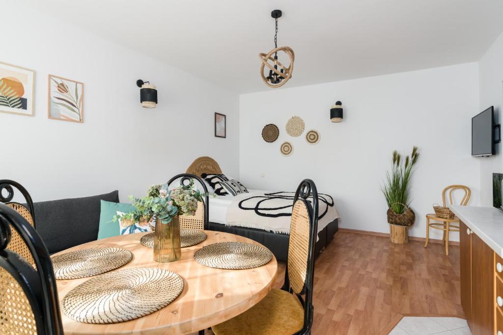 a dining room with a table and a bed at Sleepway Apartments -Boho Chic in Poznań