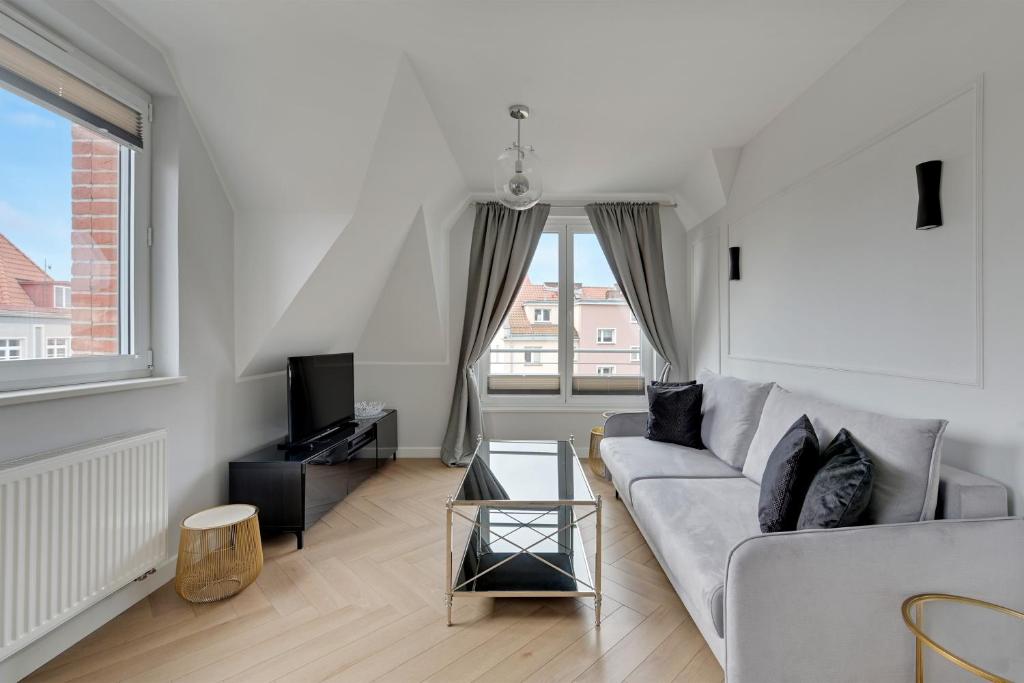 Una sala de estar con un sofá y un televisor. en Tartaczna Apartments City Center & Parking by Downtown Apartments, en Gdansk