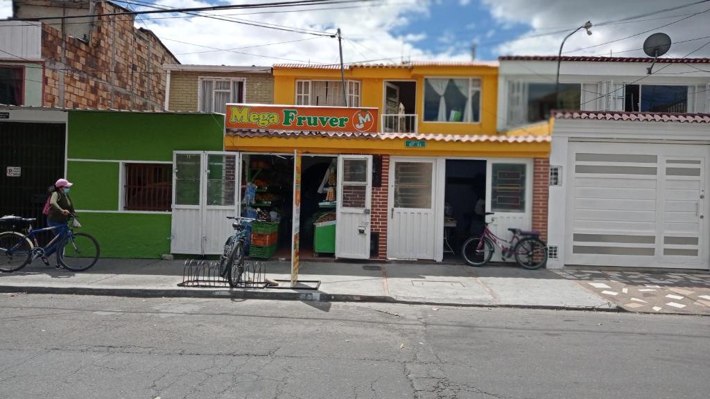 una tienda con bicicletas estacionadas fuera de ella en una calle en Habitación 5 minutos aeropuerto, en Bogotá