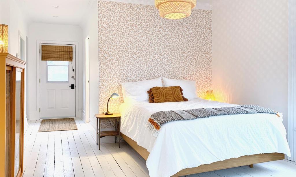 a bedroom with a white bed with a patterned wall at Flats South in Wellington