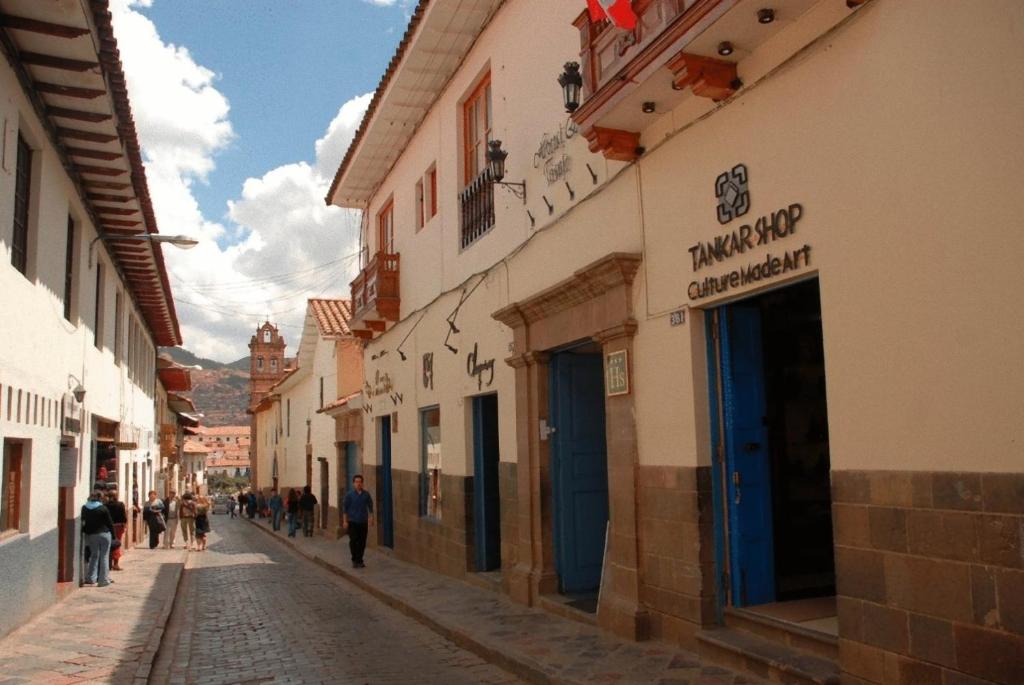 a cobblestone street in a town with buildings at Hostal & Apartments El Triunfo in Cusco