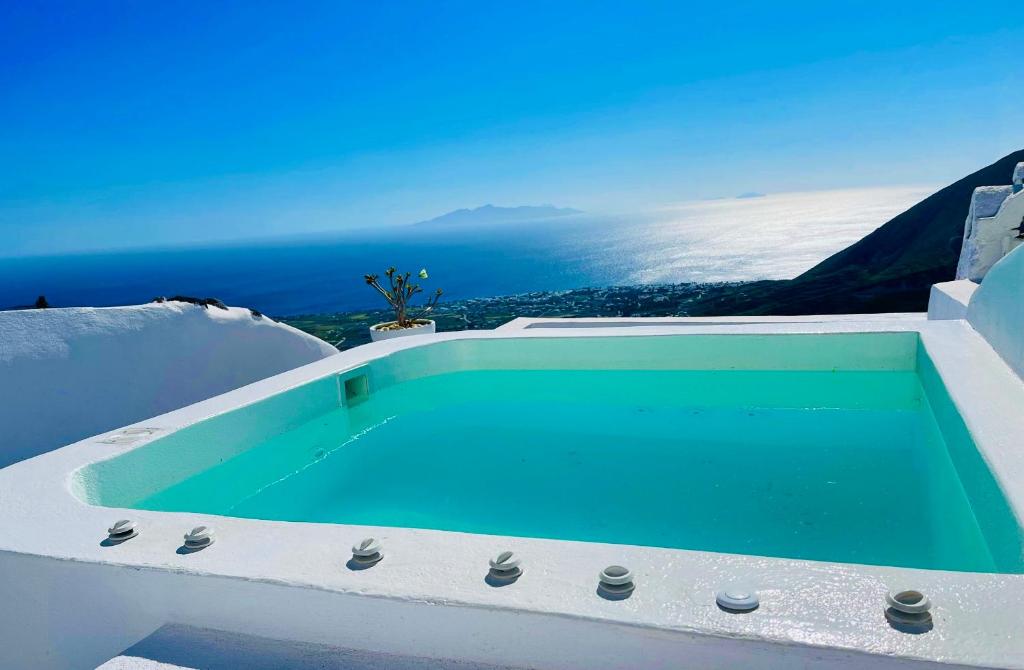 a swimming pool on top of a house with the ocean at Amphora Villas Santorini Pyrgos in Pirgos