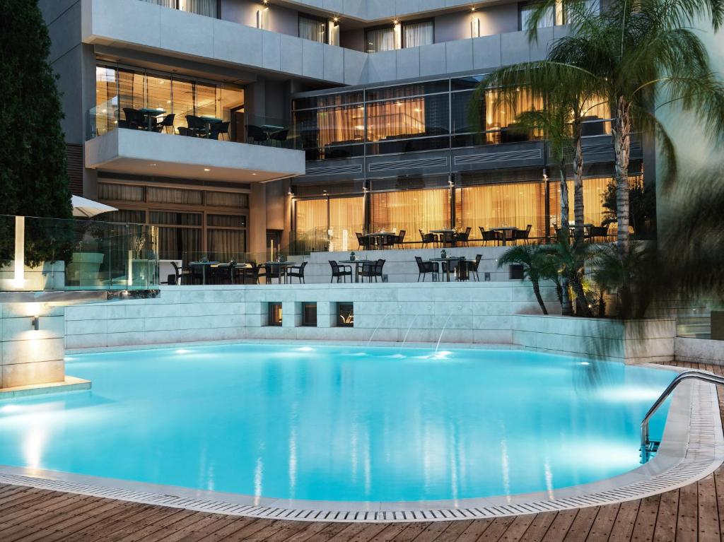 a large swimming pool in front of a building at Galaxy Iraklio Hotel in Heraklio