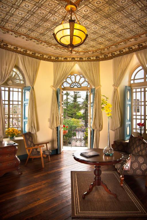 a living room with a coffered ceiling and a table at Del Parque Hotel & Suites in Cuenca