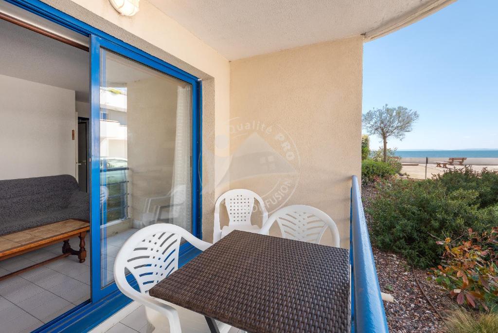 une table et des chaises sur le balcon d'une maison dans l'établissement AS21491 - P3 Cabine en bord de mer avec vue mer latérale, au Grau-du-Roi
