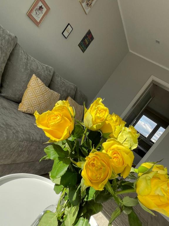 un vaso di rose gialle su un tavolo in un soggiorno di LUXURY WHITE APARTMENT by Marta a Radom