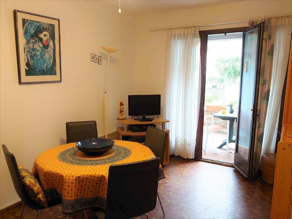 salon ze stołem, telewizorem i drzwiami w obiekcie 4PA51 Résidence du Port d'Avall w mieście Collioure
