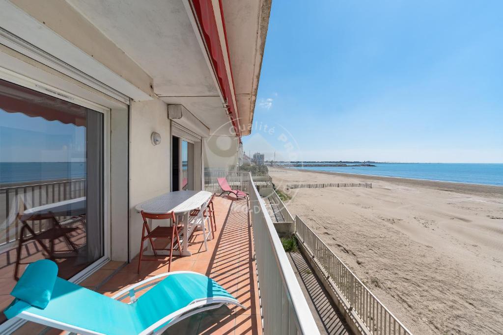 - un balcon avec une table et des chaises et la plage dans l'établissement AS18069 - P3 Vue Mer exceptionnelle , sur la plage à 2 pas du Centre Ville, au Grau-du-Roi