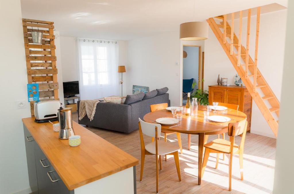 a kitchen and living room with a table and chairs at Vacances en famille a 250m de la mer a Penmarch in Penmarch