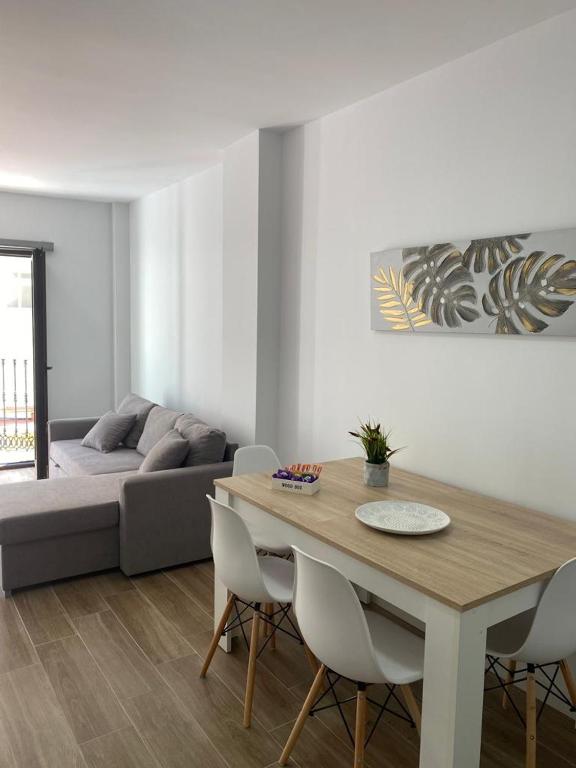 a living room with a table and a couch at APARTAMENTOS MARMOLES CENTRO in Málaga