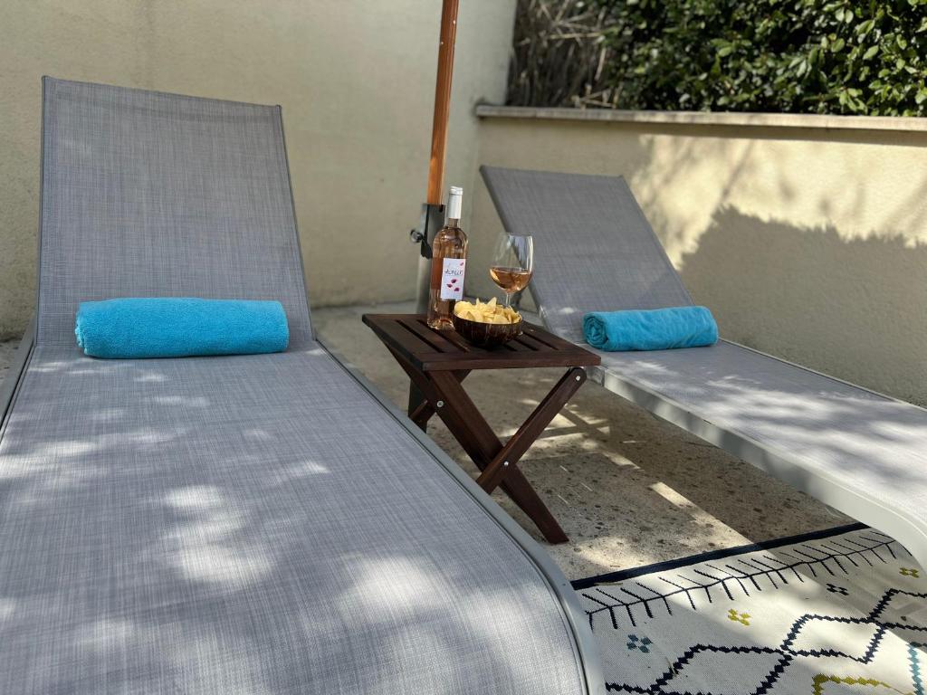 two chairs and a table with a glass of wine at Résidence Les Sources in Saint-Rémy-de-Provence