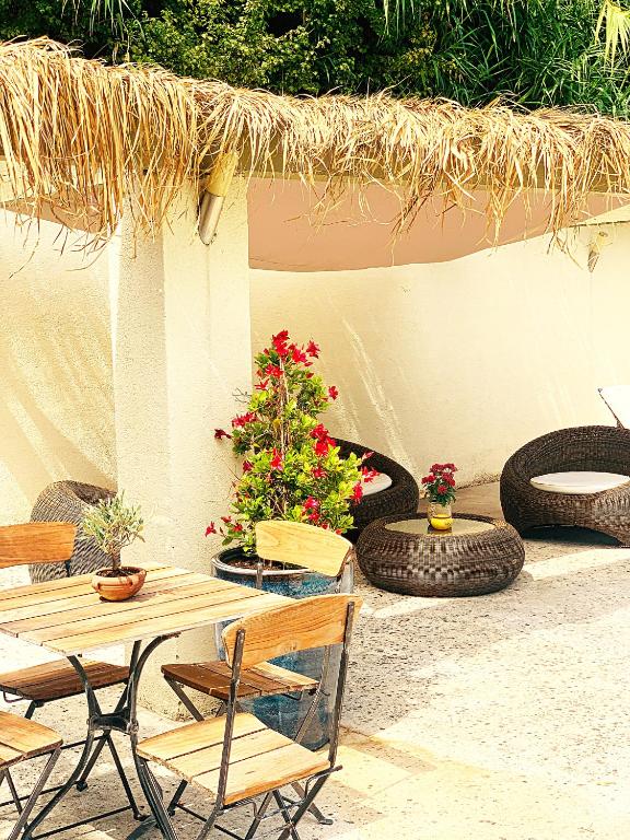 a patio with a table and chairs and some plants at Résidence Les Sources in Saint-Rémy-de-Provence