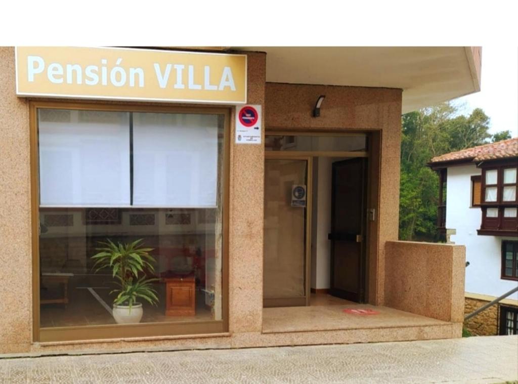 a pension villa building with a potted plant in the window at Pension Villa ** in Comillas