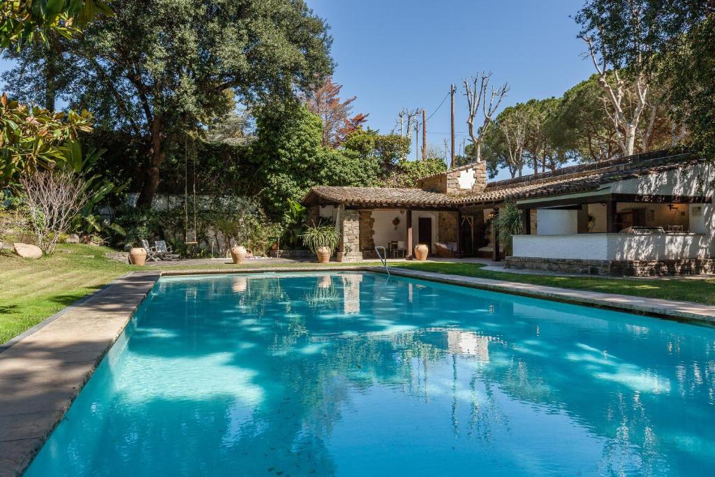 a swimming pool in front of a house at Villa Barcelona Country House in Premia de Dalt