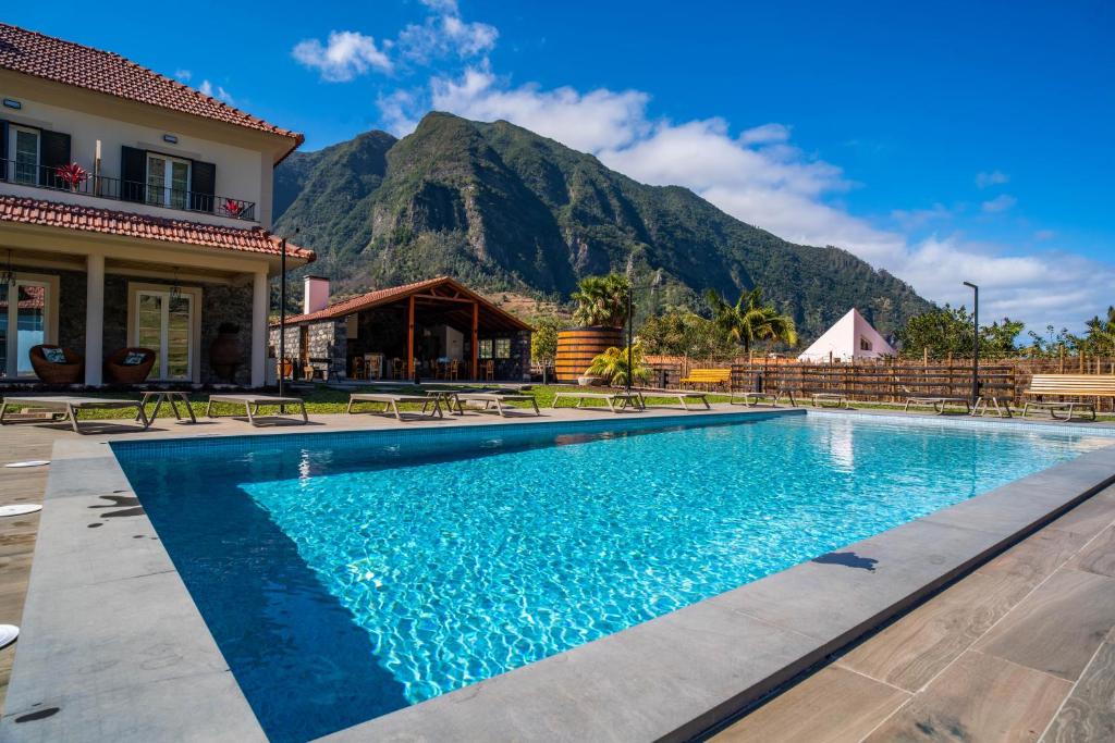 a swimming pool with a mountain in the background at Quinta Vale Vitis in São Vicente