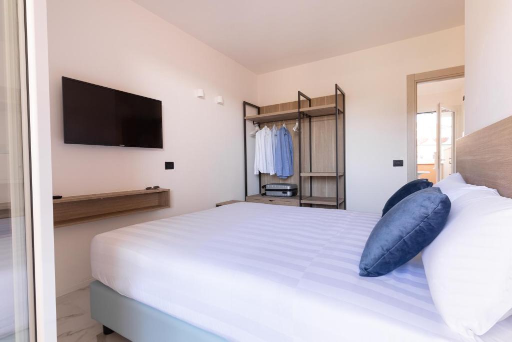 una camera da letto con un grande letto bianco con un cuscino blu di Pietra Bianca Residence a Numana
