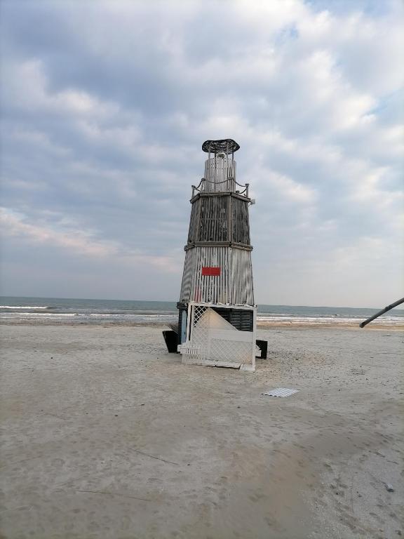 a lighthouse sitting on a beach near the ocean at Rimimi Apartamente in Mamaia Nord