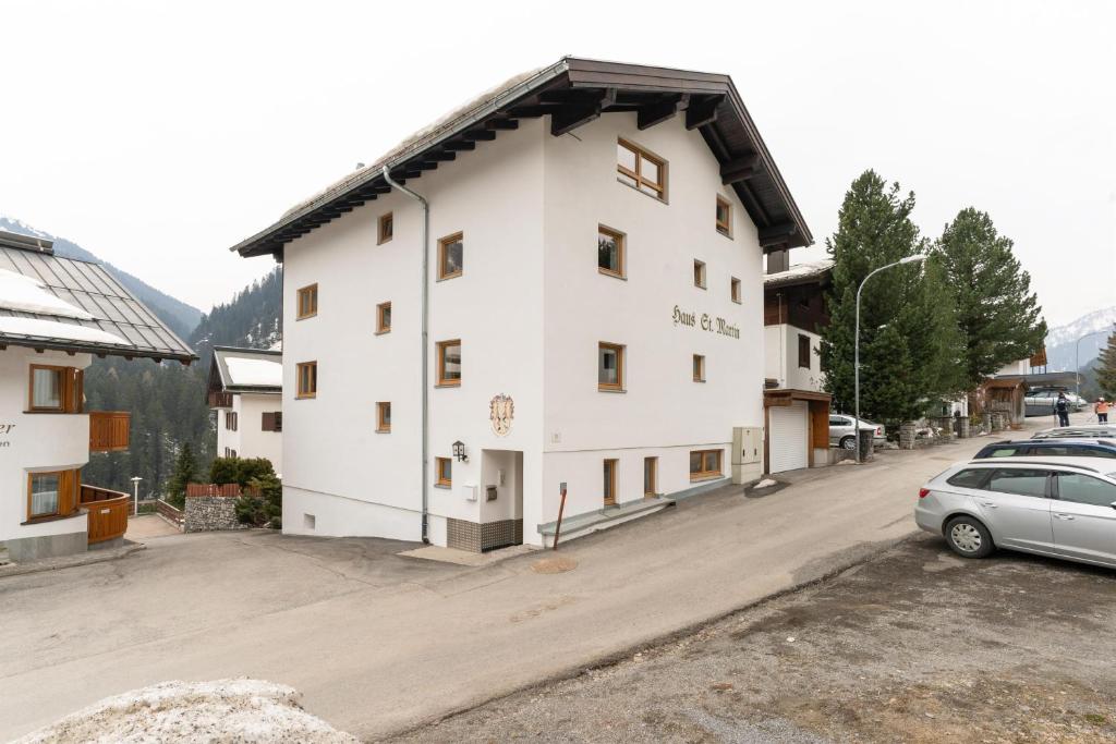 um grande edifício branco com um carro estacionado num parque de estacionamento em Chalet Martin em Sankt Anton am Arlberg
