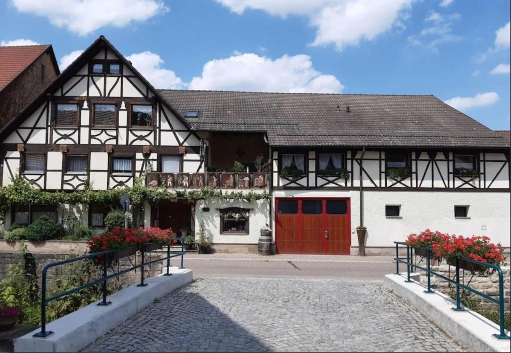 ein altes Gebäude mit roten Türen und Blumen davor in der Unterkunft Ferienwohnung "kleine galerie" in Königheim