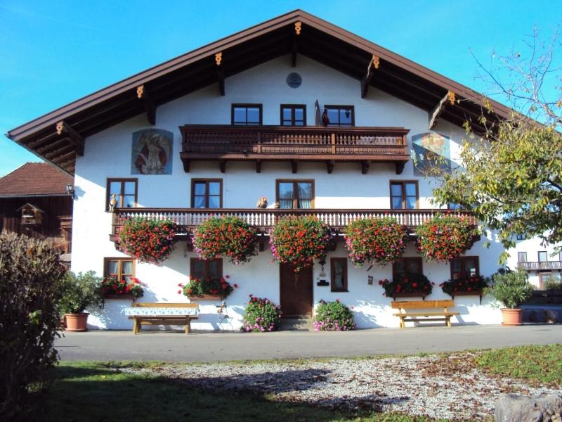 a large white building with benches in front of it at Paulhuberhof in Chieming