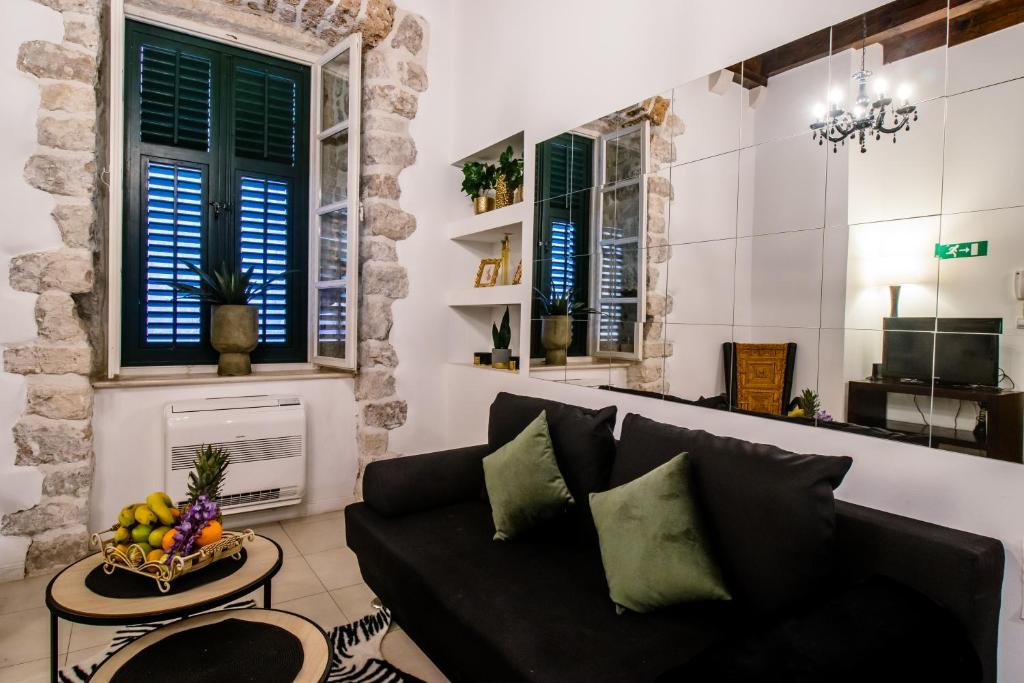 a living room with a black couch and a table at Apartment Niko, Dubrovnik in Dubrovnik