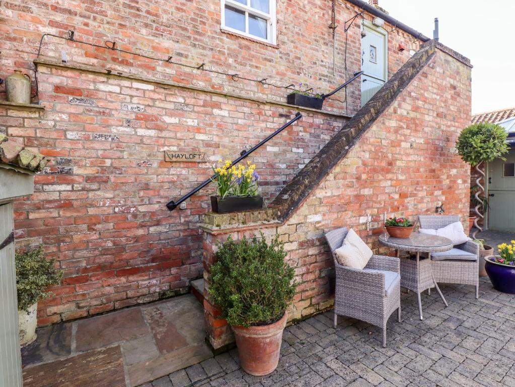 a brick wall with a table and chairs on a patio at The Hayloft in Skegness
