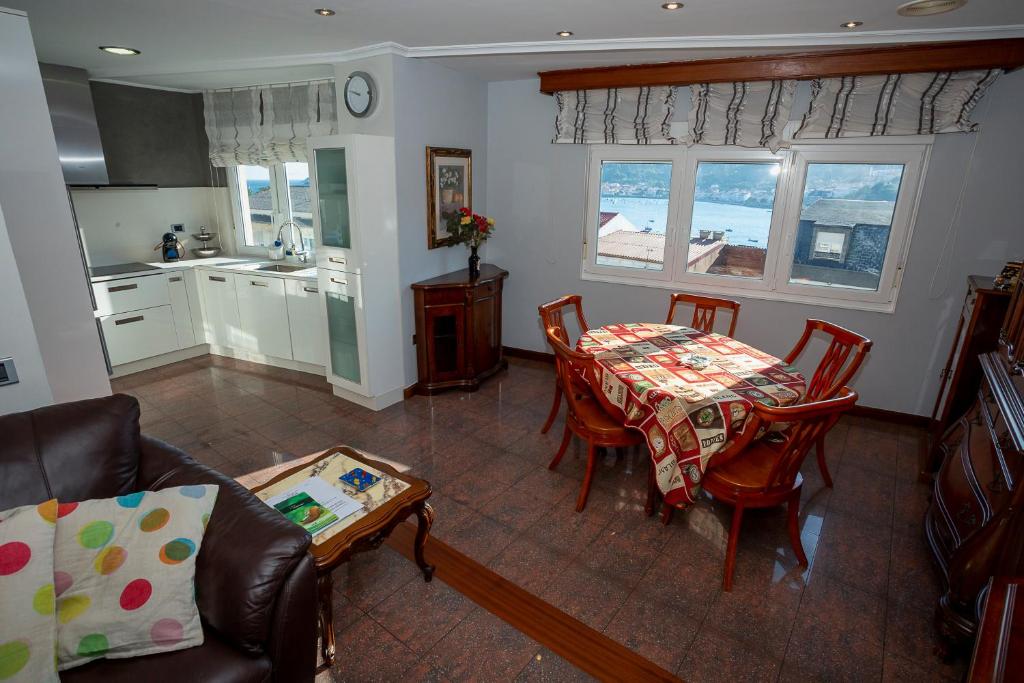 a living room with a table and a kitchen at Piso Angueira in Cee