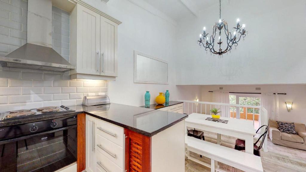 a kitchen with a chandelier and a table in it at San Lameer Villa 3002 by Top Destinations Rentals in Southbroom