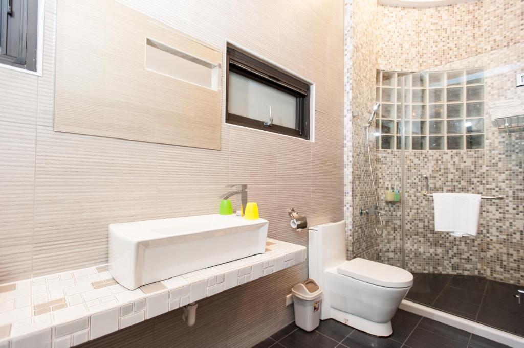 a bathroom with a sink and a toilet and a shower at Discovery B&amp;B in Linbian