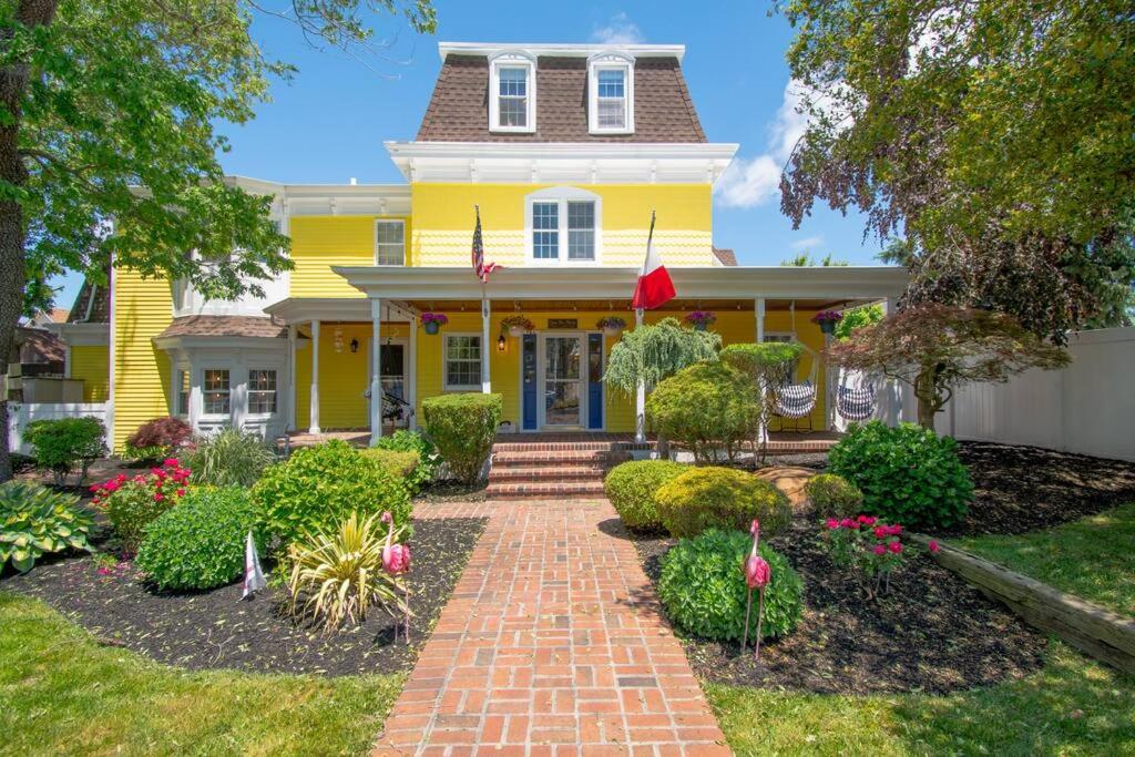 a yellow house with a brick walkway at Gorgeous historic Victorian with 8 bedroom/4 baths in Wildwood