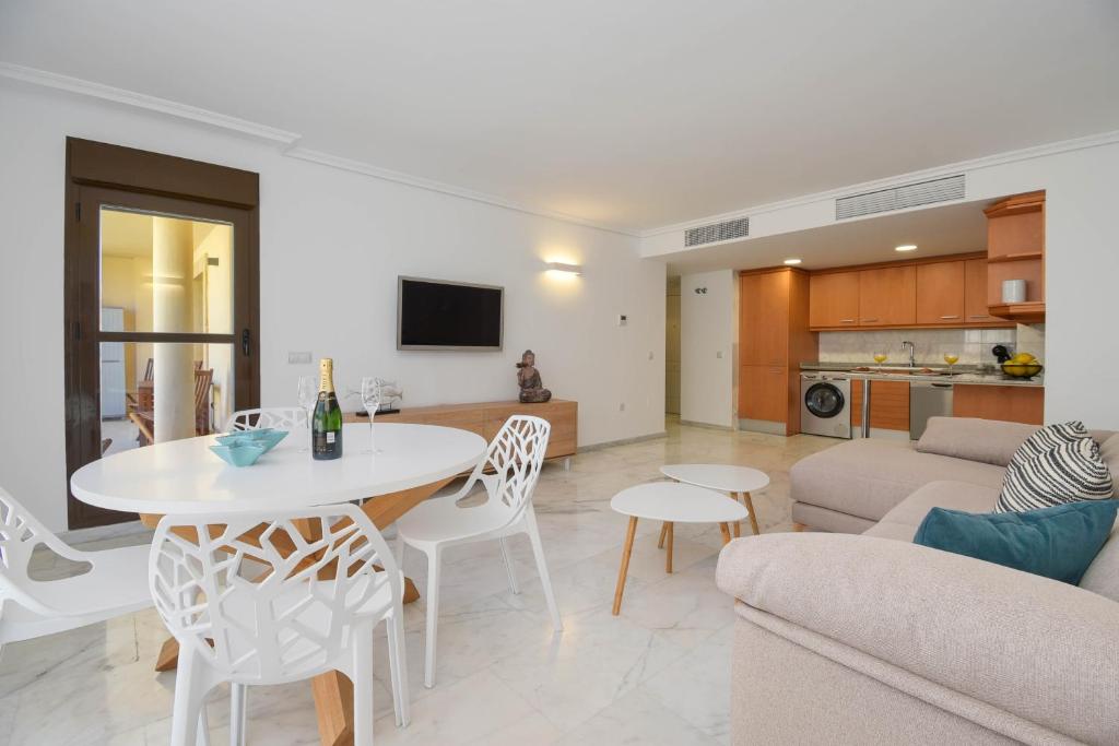 ein Wohnzimmer und eine Küche mit einem Tisch und Stühlen in der Unterkunft Apartamento en Moraira Moramar in Moraira