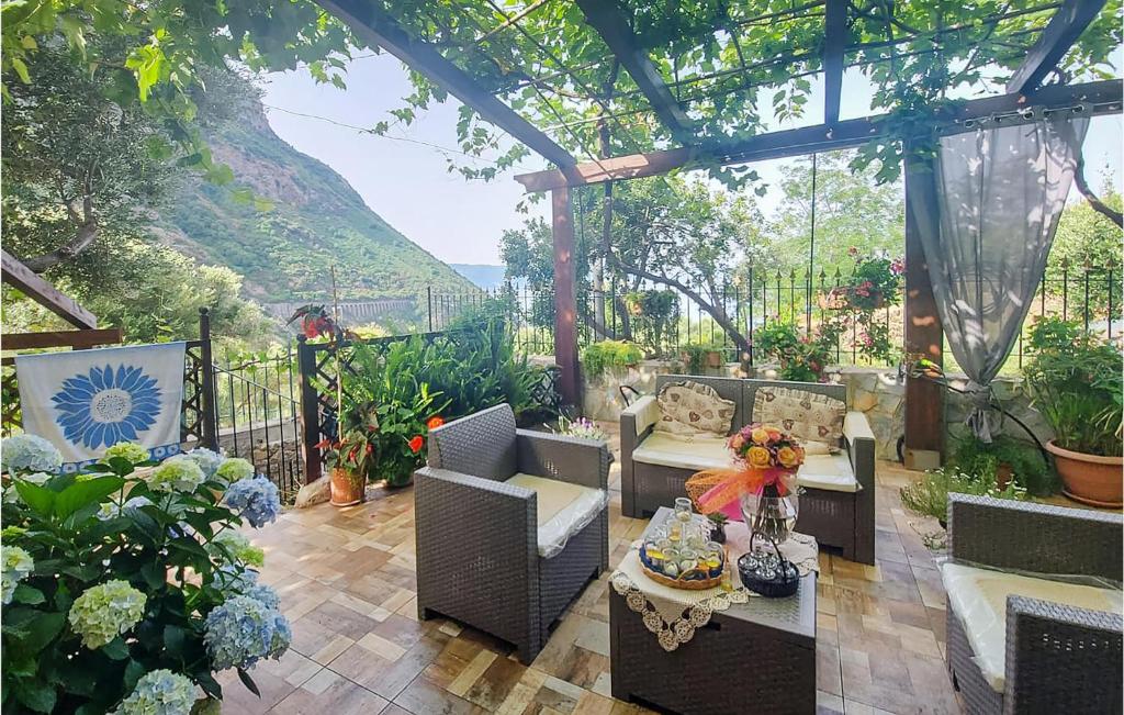 un patio con sillas y una mesa con flores. en Stunning Home In Palmi With Wifi, en Palmi
