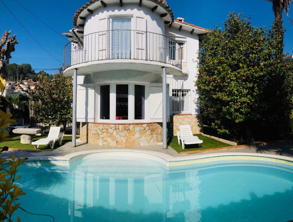 une villa avec une piscine en face d'une maison dans l'établissement CasasMontseny, à Arbúcies