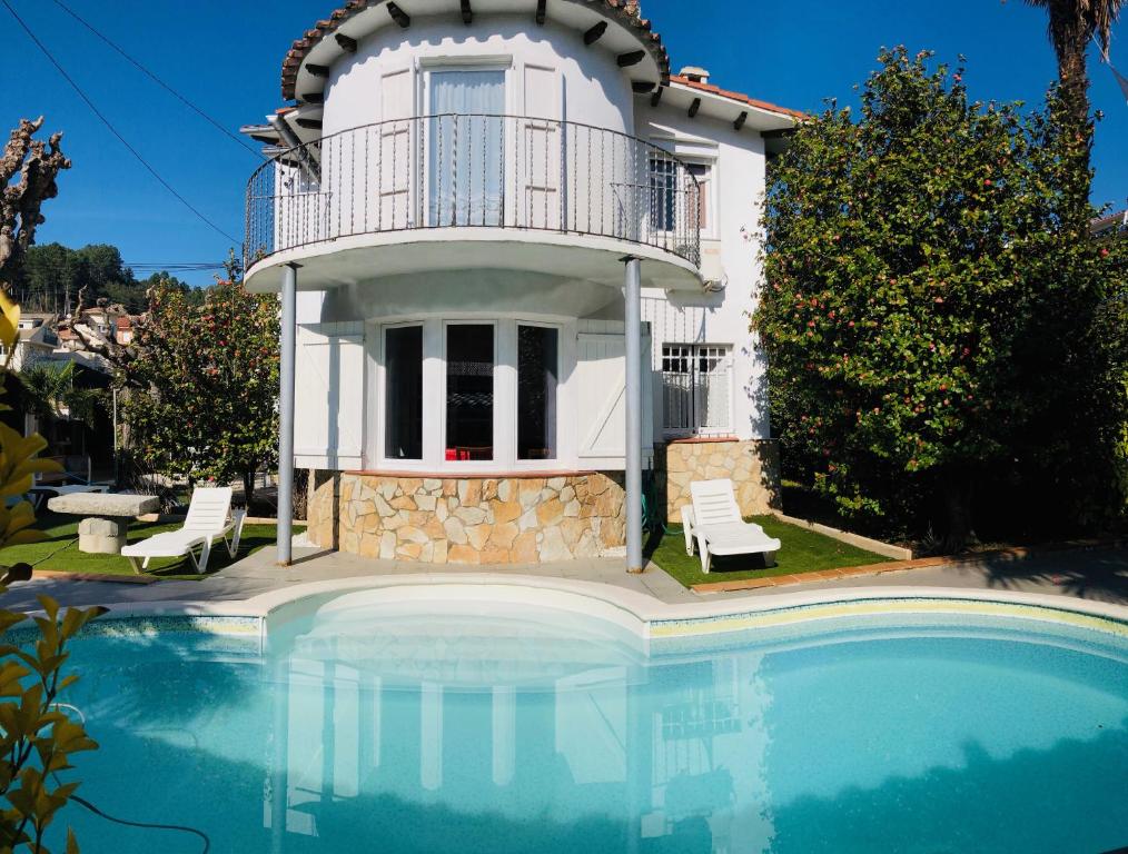 a villa with a swimming pool in front of a house at CasasMontseny in Arbúcies