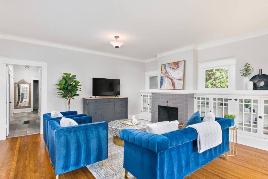 uma sala de estar com duas cadeiras azuis e uma lareira em Powell Place em Gresham