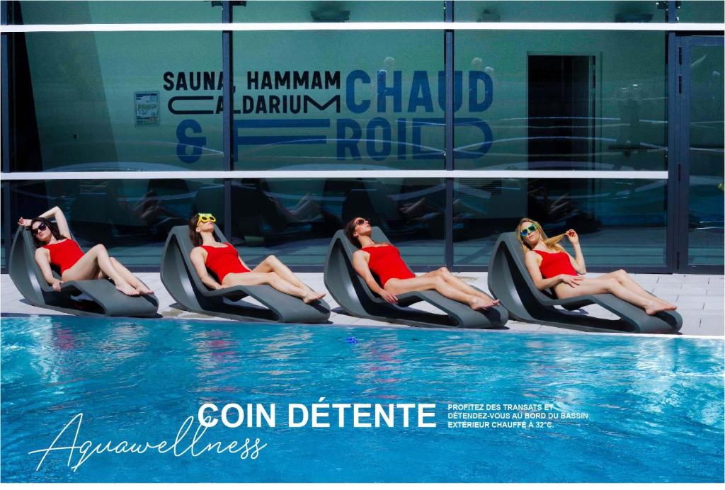 a group of women sitting in chairs next to a swimming pool at Ecrin Blanc Resort Courchevel in Courchevel