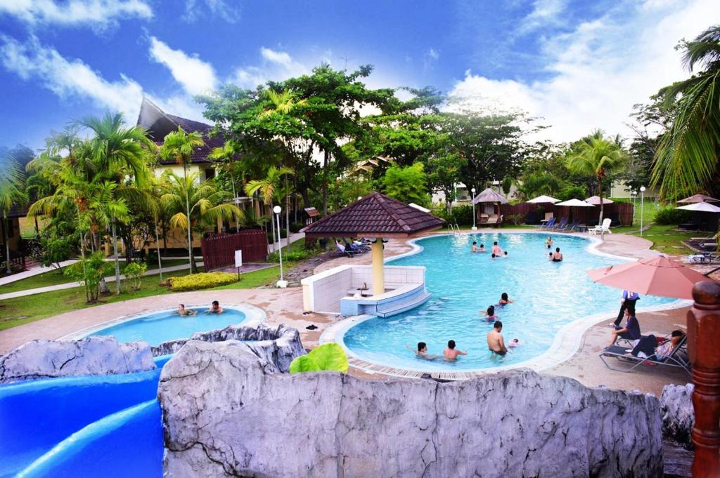 a group of people in a pool at a resort at Beringgis Beach Resort & Spa in Papar