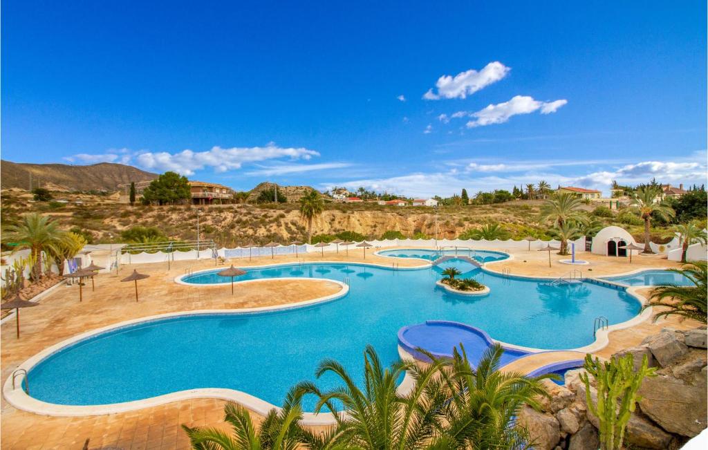 a large swimming pool in a resort with palm trees at 3 Bedroom Gorgeous Home In El Campello in El Campello