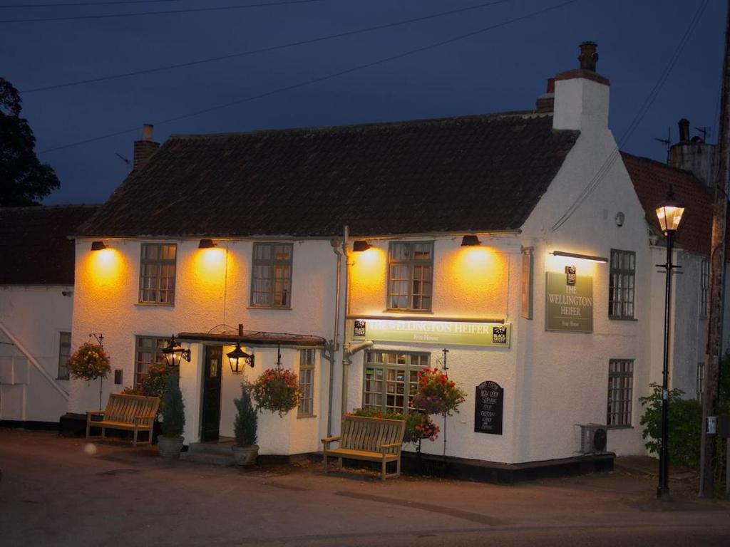 un edificio blanco con bancos delante en The Wellington Heifer, en Northallerton