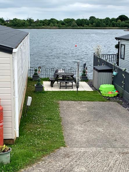 a backyard with a picnic table next to a lake at Lovely 4 berth caravan on 7 Lakes Country Park at Crowle North Lincolshire in Crowle