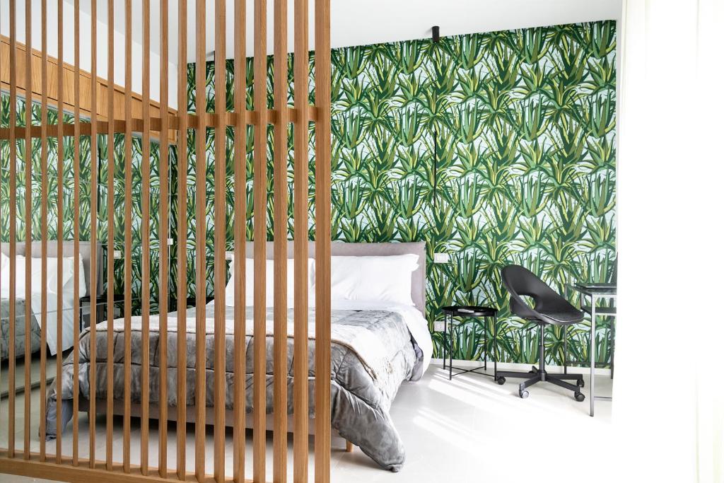 una camera da letto con un letto e carta da parati verde di Antichi Soffitti a Catania