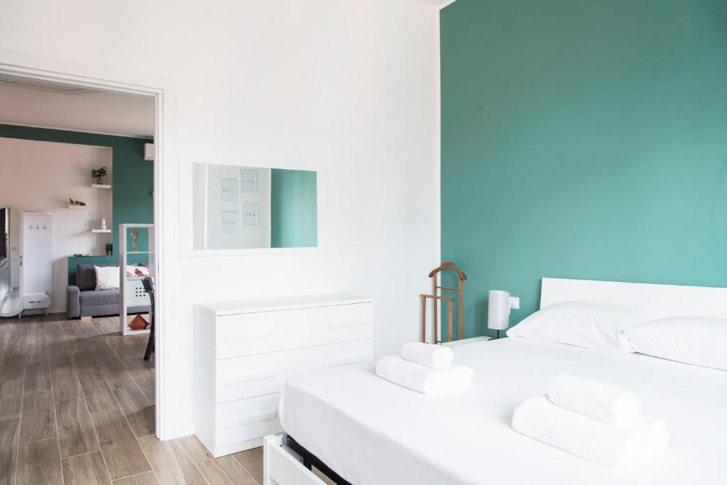 a bedroom with a white bed and a mirror at YouHosty - 25 Aprile 5 in Milan